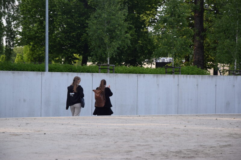 Junge Personen laufen zusammen über das Gelände einer Gedenkstätte.