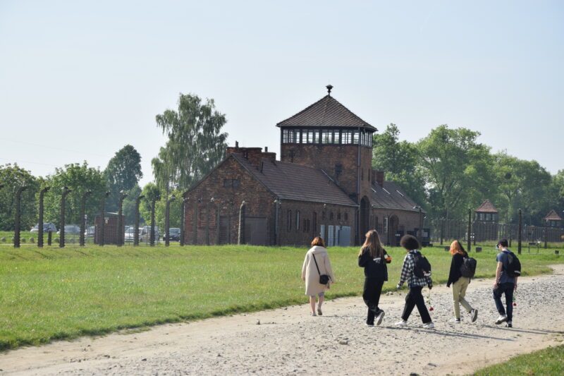 Junge Personen laufen zusammen über das Gelände einer Gedenkstätte.