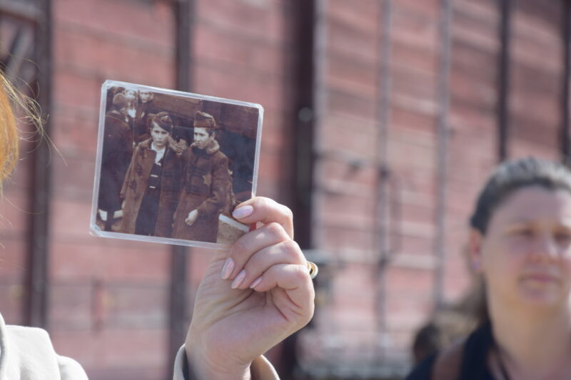 Nahaufnahme einer Hand die ein altes Foto von zwei jungen Personen hält.