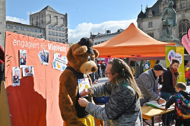 Eine Perso bringt eine Laufnummer an einem Bär-Maskottchen an.